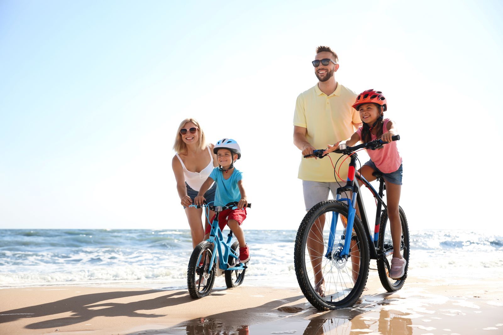 Family of four biking on beach